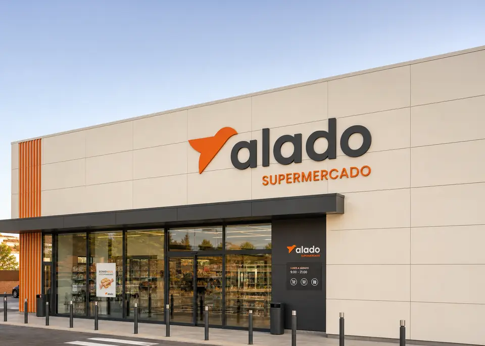 Fachada de un supermercado Alado con el logotipo y la palabra «supermercado» en naranja