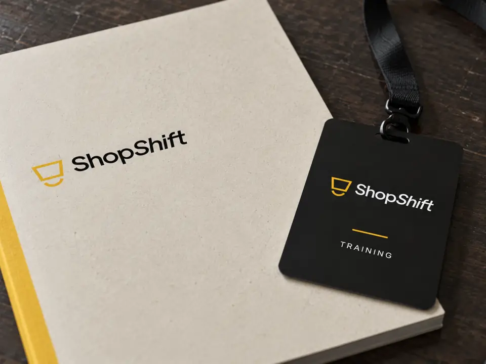 Cuaderno y acreditación con el logotipo de ShopShift